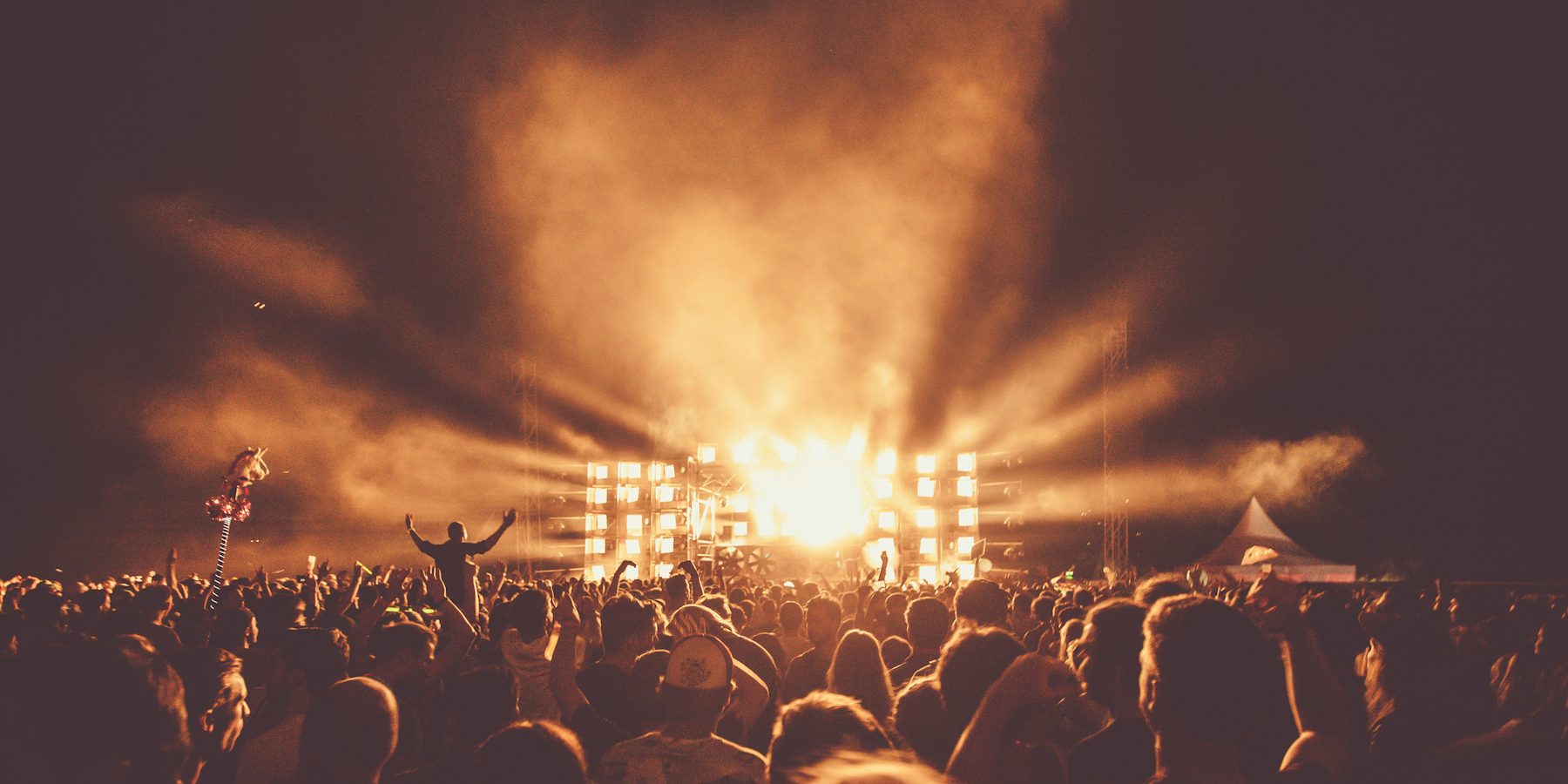 Glowing stage lights behind a large audience