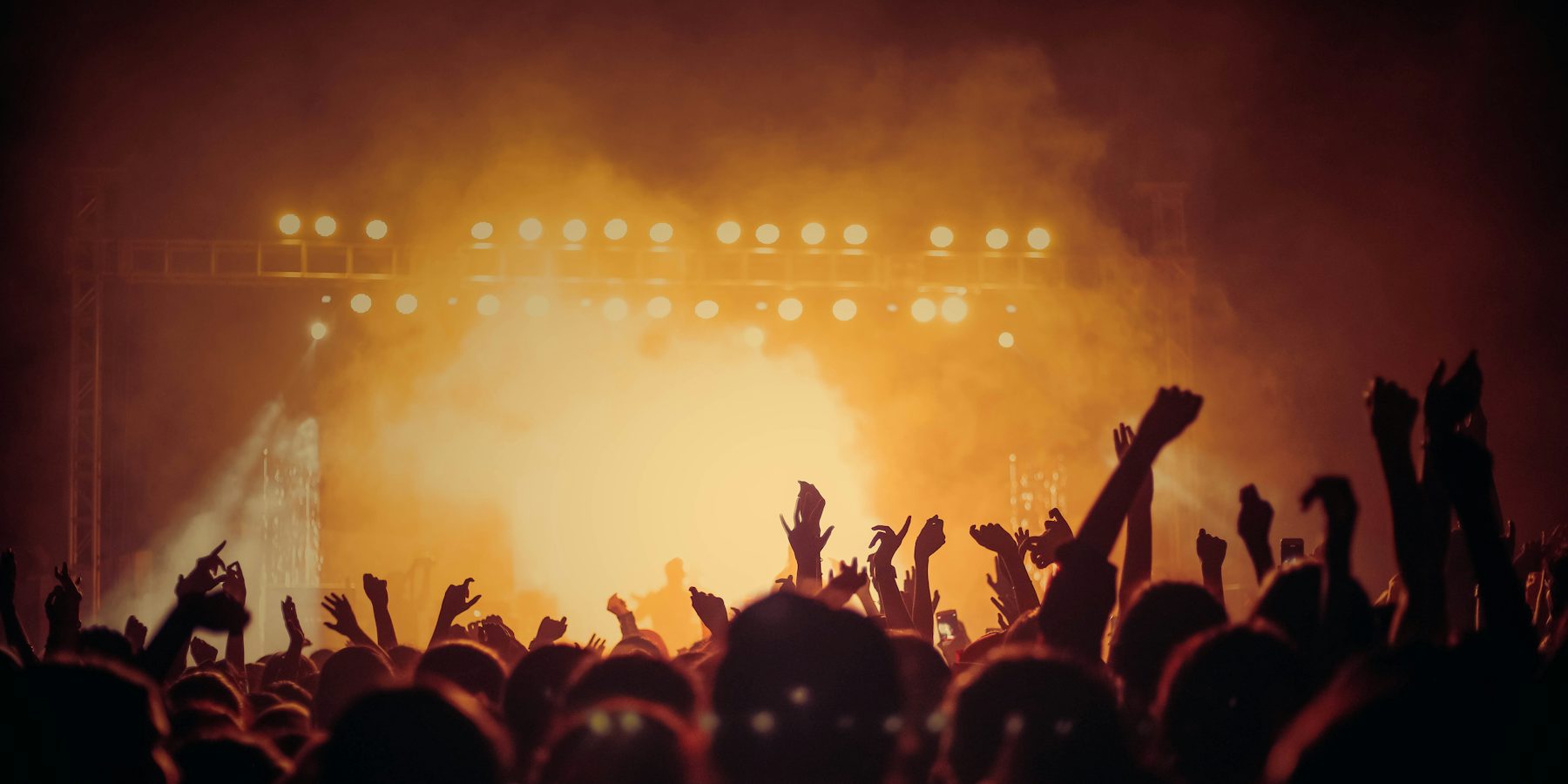 Warm stage lighting above a cheering crowd