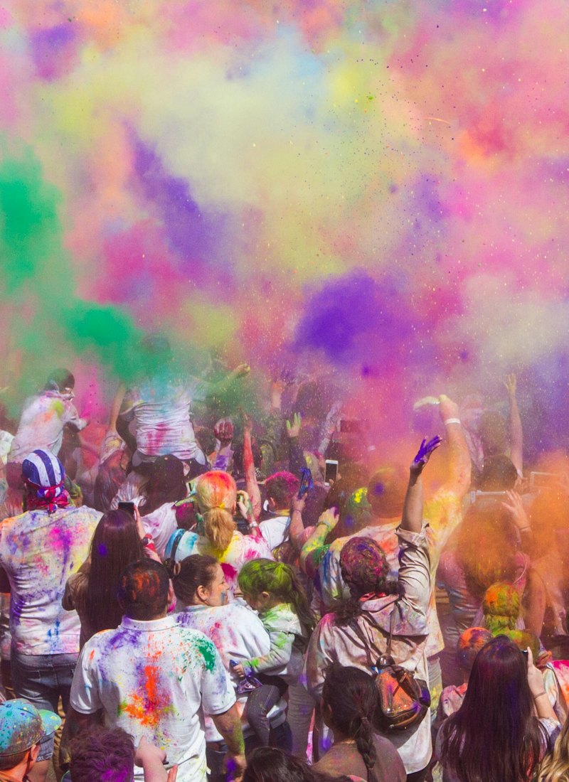 Celebrants throwing colourful powder at a cultural festival