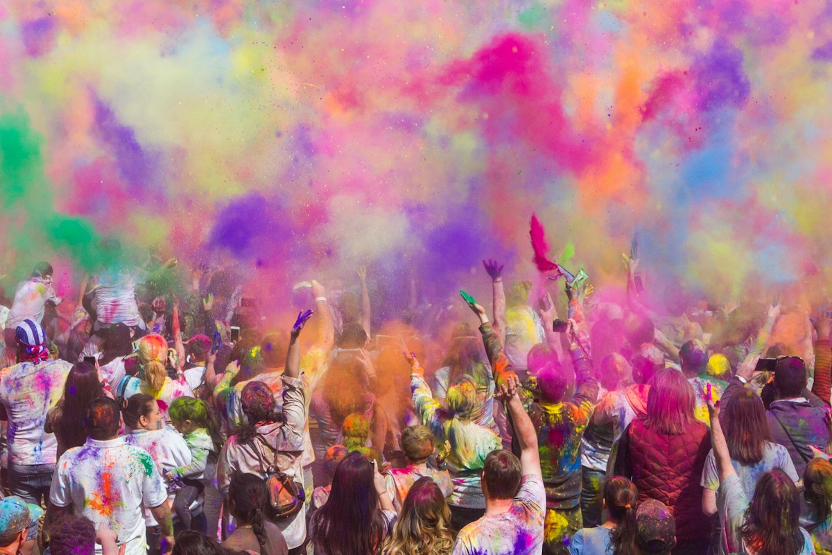Celebrants throwing colourful powder at a cultural festival