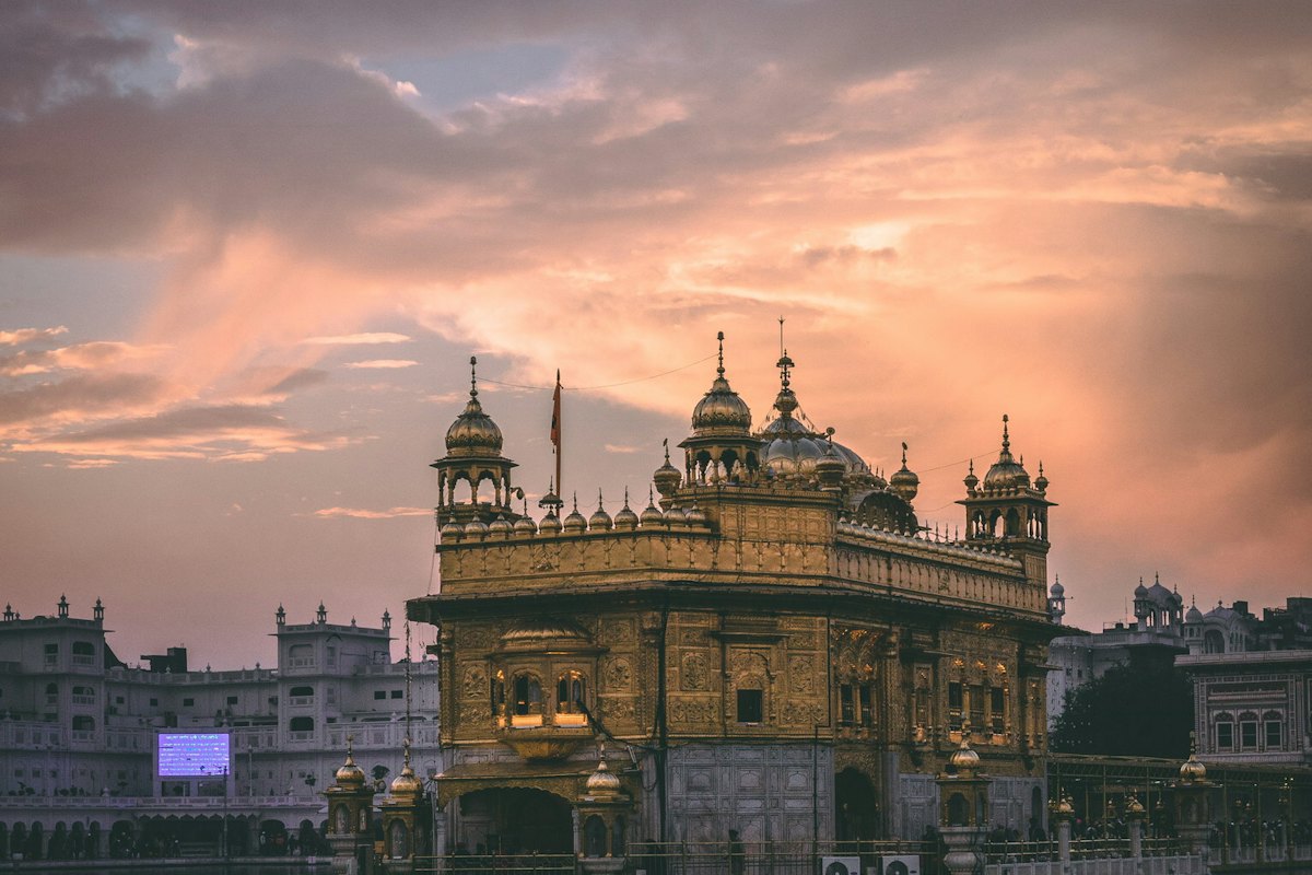Golden temple reflected in water at dusk