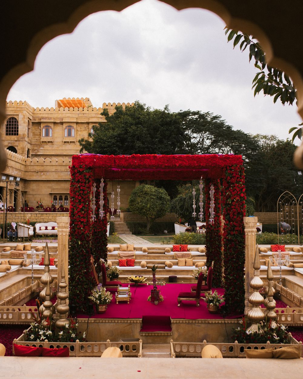 Red and gold wedding mandap in a royal fort courtyard
