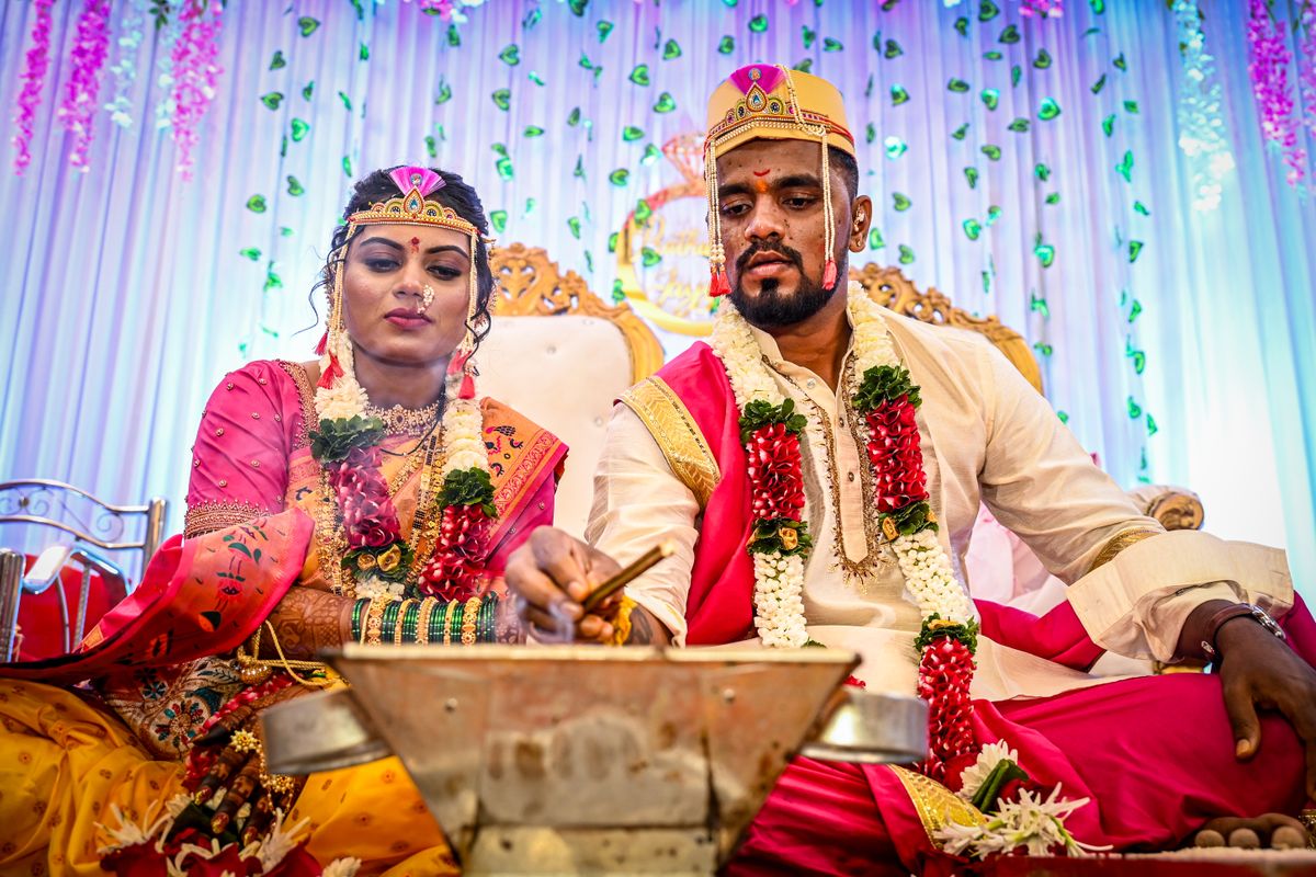 Bride and groom performing wedding rituals in traditional attire