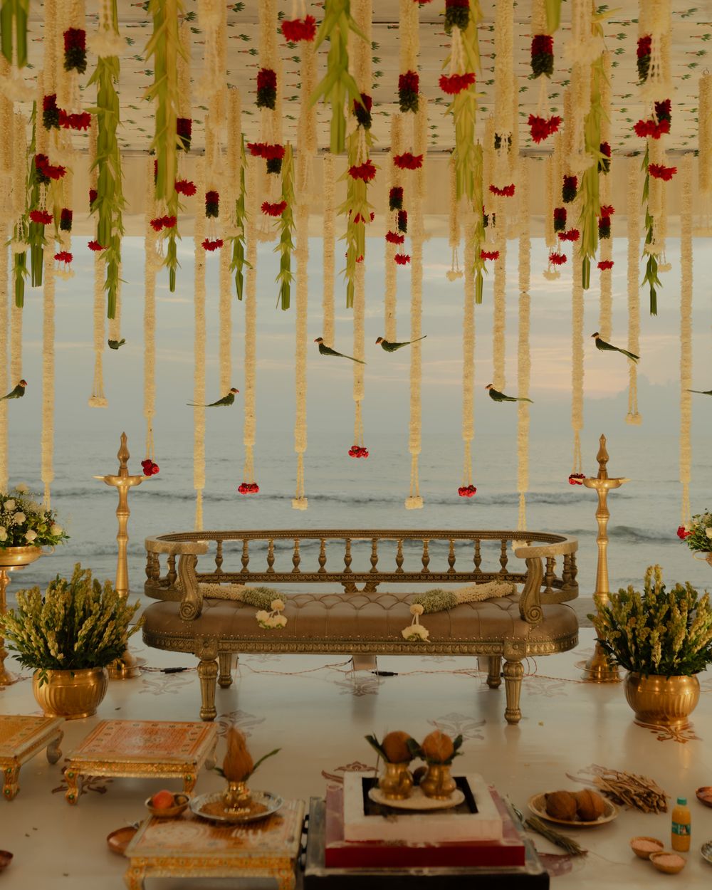 Floral wedding mandap with hanging garlands beside the sea