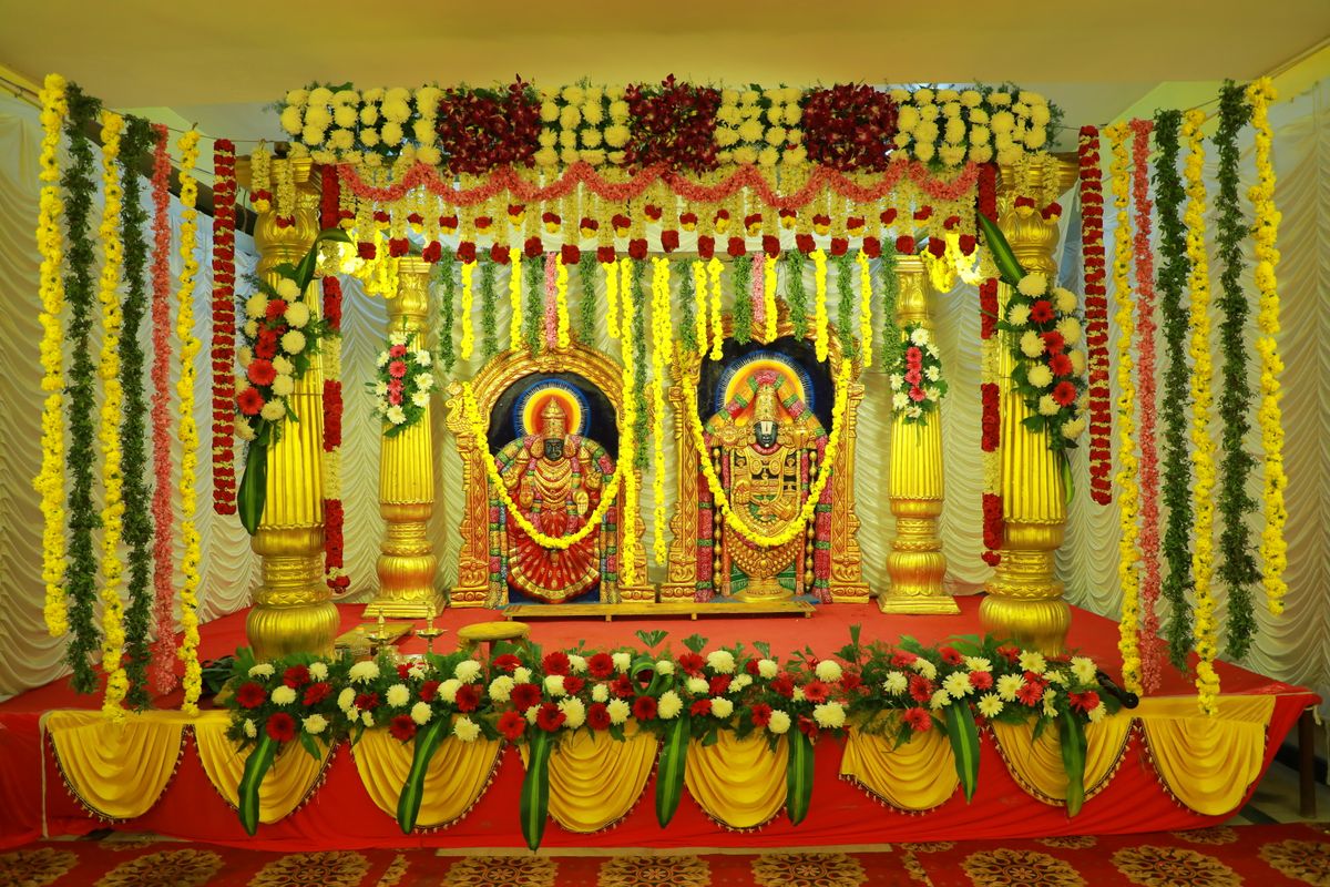 Wedding stage decorated with flowers, gold and red armchairs