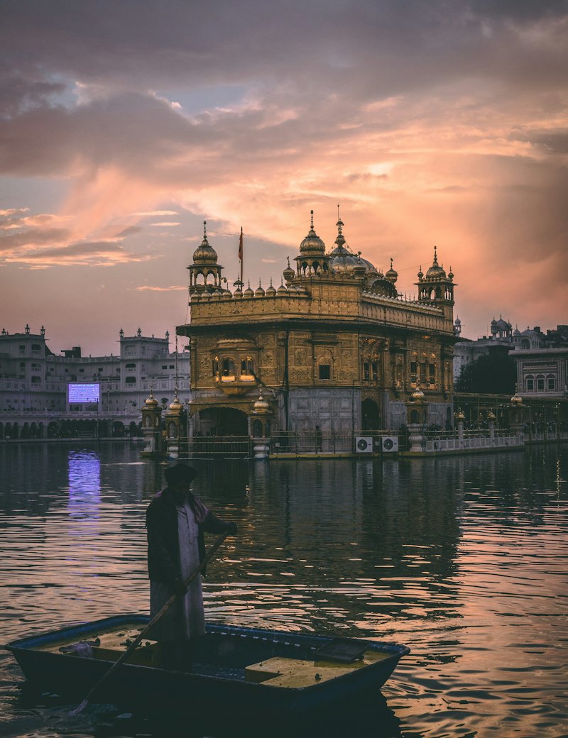 Golden temple reflected in water at dusk