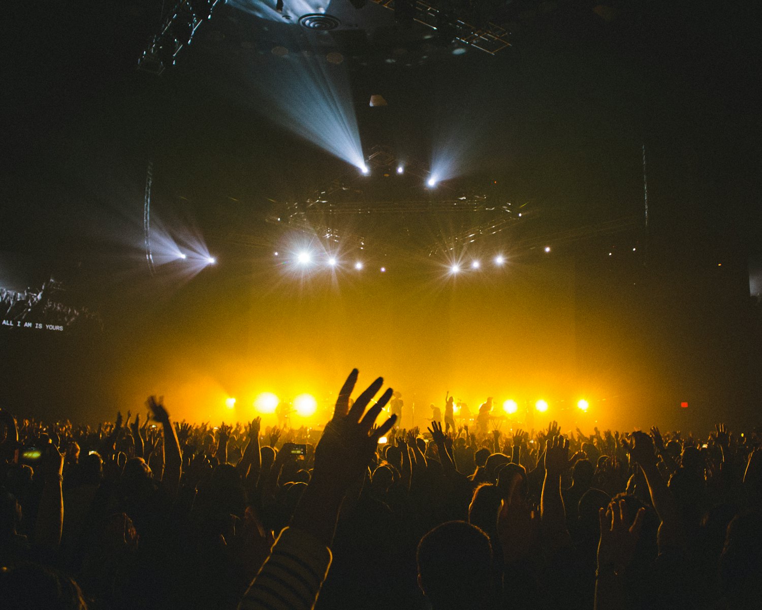 Concert stage lit in amber with an audience below