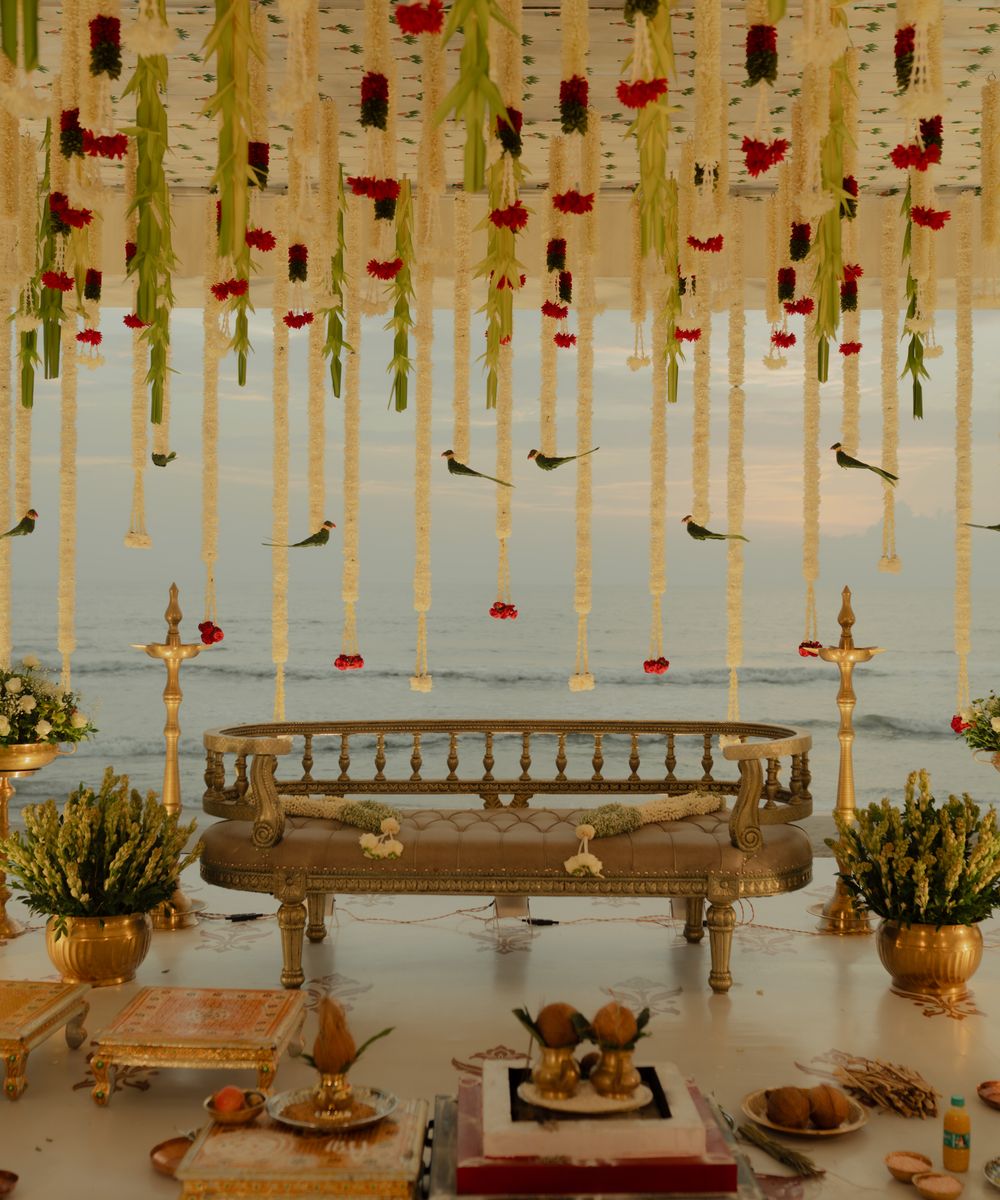 Floral wedding mandap with hanging garlands beside the sea